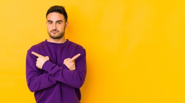 Beyaz tenli genç adam, iki seçenek arasında seçim yapmaya çalışıyor..