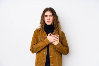 Yalnız poz veren uzun saçlı adam, avuçlarını göğsüne bastıran dostça bir ifadeye sahiptir. Aşk konsepti.