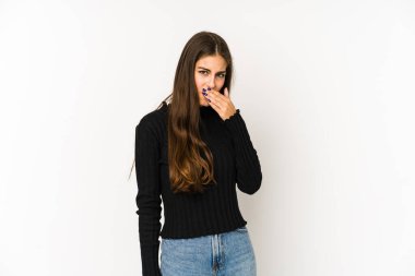 Beyaz arka planda izole edilmiş beyaz tenli genç bir kadın elleri endişeli bir şekilde ağzı örtüyor..