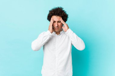 Genç, kıvırcık, olgun, zarif bir gömlek giyen, şakaklara dokunan ve baş ağrısı çeken bir adam..