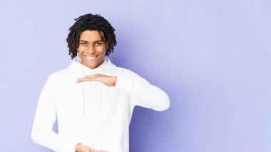 Genç Afrikalı Amerikalı Rasta adam iki eliyle bir şey tutuyor, ürün sunumu..