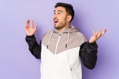 Mor arka planda izole edilmiş genç beyaz adam gökyüzüne haykırıyor, yukarı bakıyor, hayal kırıklığına uğramış..