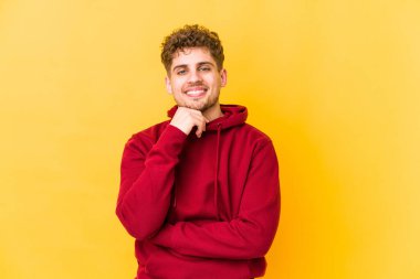  Mutlu ve kendinden emin gülümsüyor, elleriyle çeneye dokunuyor..