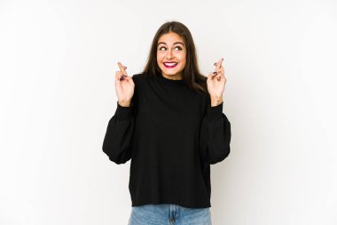 Beyaz arka planda izole genç beyaz kadın şans dilemek için parmaklarını çapraz