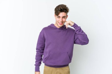 Beyaz arka planda izole olmuş genç beyaz bir adam bir şeye gülüyor, ağızlarını ellerle kapatıyor..