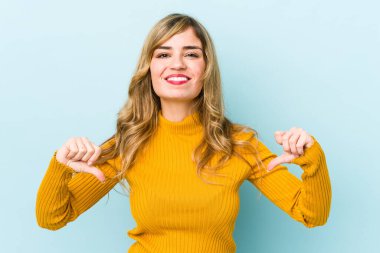 Sarışın, beyaz bir kadın parmaklarıyla aşağıya bakıyor, olumlu bir his..