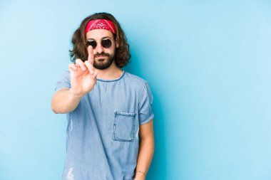 Genç, uzun saçlı, festival elbisesi giyen hippi, bir numarayı parmağıyla göstererek soyutlanmış görünüyor..