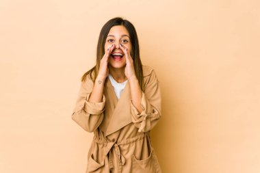 Bej arka planda izole edilmiş genç bir kadın bir dedikodu söylüyor, bir haber sunuyor..