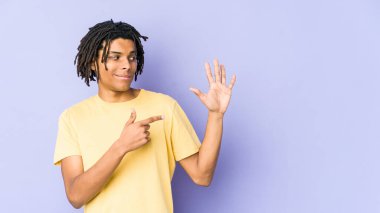 Genç Afrikalı Amerikalı Rasta adam gülümseyerek beş numarayı parmaklarıyla gösteriyor..