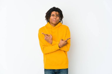 Genç Afrikalı Amerikalı Rasta adam iki seçenek arasında seçim yapmaya çalışıyor..