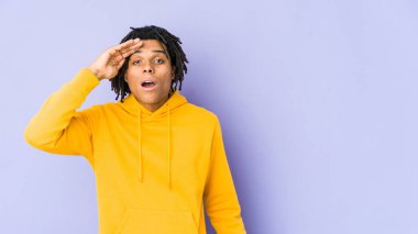 Genç Afrikalı Amerikalı Rasta adam yüksek sesle bağırıyor, gözleri açık ve elleri gergin tutuyor..