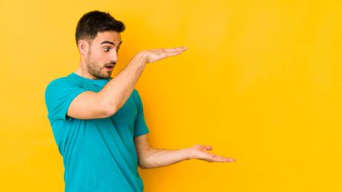 Sarı fırında izole edilmiş genç beyaz adam elleri arasında bir kopya alanı tutarken şok ve hayrete düştü..