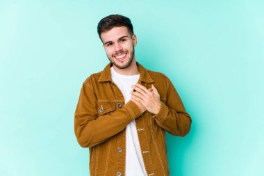 Genç ve yakışıklı bir adamın, avuçlarını göğsüne bastıran samimi bir ifadesi var. Aşk konsepti.