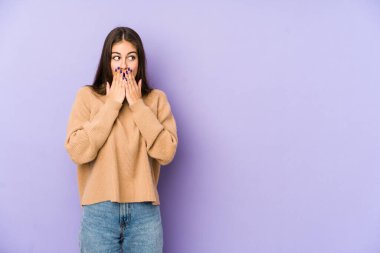 Mor arka planda izole edilmiş beyaz bir kadın. Elle ağzını kapatan bir fotokopi odasına bakıyor..