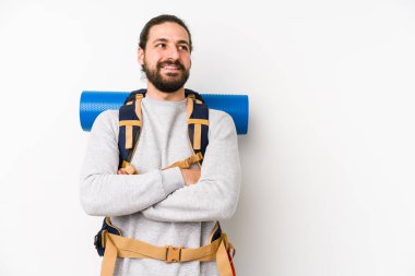 Sırt çantalı genç adam beyaz bir arka planda izole edilmiş. Kollarını kavuşturarak gülümsüyor..