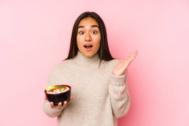 Elinde erişte tutan genç Asyalı kadın şaşırdı ve şok oldu..