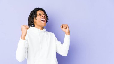 Genç Afrikalı Amerikalı Rasta adam zafer ve galibiyet kavramından sonra yumruğunu kaldırıyor..