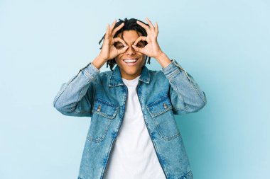 Kot ceket giyen genç siyahi bir adam heyecanlı..