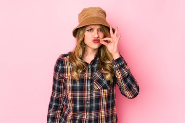 Şapka takan genç beyaz kadın dudaklarında parmaklarıyla bir sır saklıyor..