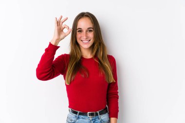 Kafkasyalı genç bir kadın yalnız poz veriyor neşeli ve kendinden emin, iyi bir hareket gösteriyor..