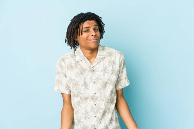 Genç Afrikalı Amerikalı Rasta adam omuz silker ve gözleri açık bakar..