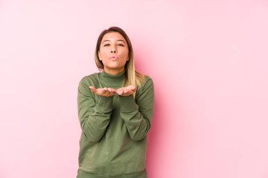 Kafkasyalı genç bir kadın yalıtılmış, katlanmış dudaklar ve hava öpücüğü yollamak için avuç içleri tutuyor..