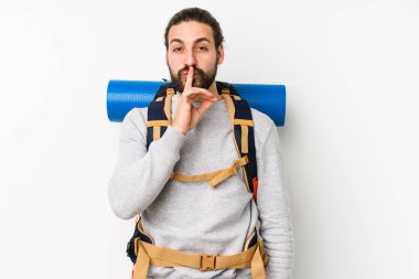 Sırt çantalı genç adam beyaz bir arka planda izole edilmiş bir şekilde bir sır saklıyor ya da sessizlik istiyor..