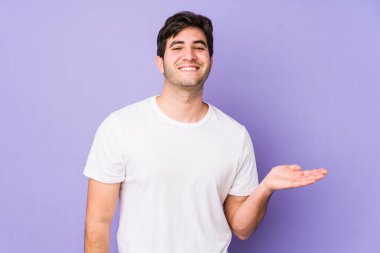 Mor arka planda izole edilmiş genç bir adam bir avuç içinde fotokopi alanı ve belinde başka bir el tutuyor..