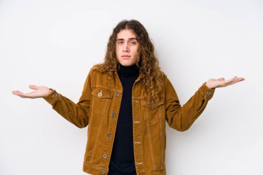 Uzun saçlı adam kuşkuyla poz veriyor ve sorgulamada omuz silkiyor..