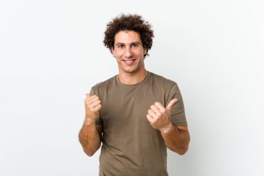 Olgun, yakışıklı bir adam kendini soyutlamış iki parmağını kaldırıyor, gülümsüyor ve kendinden emin..