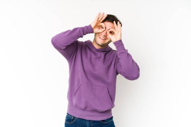 Genç adam beyaz arka planda izole edilmiş. Gözlerinde işaret var.