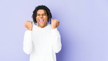 Genç Afro-Amerikan Rasta adamı gamsız ve heyecanlı bir şekilde tezahürat yapıyor. Zafer konsepti.