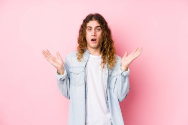 Uzun saçlı adam yalnız poz veriyor şaşırmış ve şok olmuş..