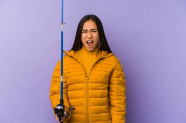 Mor arka planda izole edilmiş genç bir balıkçı çok sinirli ve agresif bağırıyor..