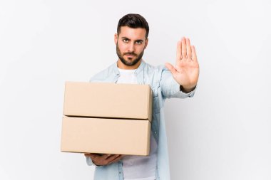 Kafkas 'lı genç bir adam yeni bir eve taşınıyor. Tek başına duruyor. Elini uzatmış, dur işareti gösteriyor..