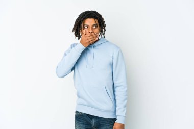 Genç Afro-Amerikan Rasta adam düşünceli bir şekilde bir fotokopi odasına bakıyor ağzını eliyle kapatıyor..