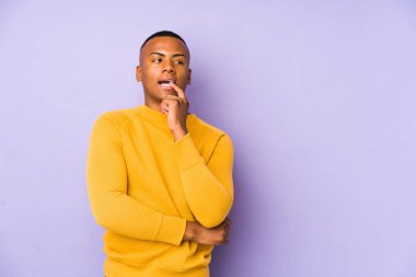 Mor arka planda izole olmuş genç latin adam rahatlamış bir şeyin fotokopi odasına baktığını düşünüyor..