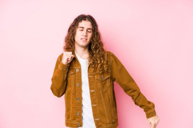 Genç, uzun saçlı adam yalnız dans ediyor ve eğleniyor..