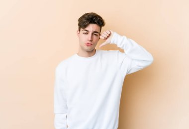 Beyazlı genç bir adam bej arka planda izole edilmiş, hoşlanmadığı bir hareket sergiliyor, kabul etmiyor. Anlaşmazlık konsepti.
