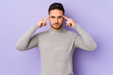 Morarmış arka planda izole edilmiş genç beyaz adam bir göreve odaklanmış, parmaklarını işaret ediyor..