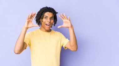 Genç Afrikalı Amerikalı Rasta adam zaferi ya da başarıyı kutluyor. Şaşırdı ve şok oldu..