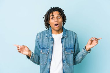 Farklı fotokopi alanlarını gösteren kot ceket giyen genç siyahi bir adam, birini seçiyor, parmaklarıyla gösteriyor..