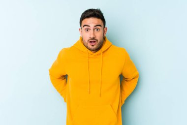 Kafkasyalı genç adam mavi arka planda izole edilmişti. Gördüğü bir şey yüzünden şok olmuştu..