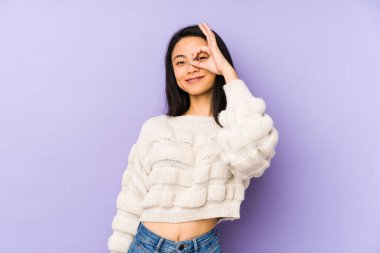 Mor arka planda izole edilmiş genç Çinli bir kadın heyecanlı..