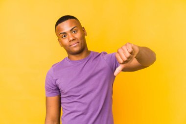 Sarı arka planda izole edilmiş genç latin adam hoşlanmadığı bir hareket gösteriyor. Anlaşmazlık konsepti.