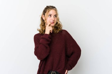 Beyaz sırtlı beyaz bir kadın şüpheli ve şüpheci bir ifadeyle yan bakıyor..