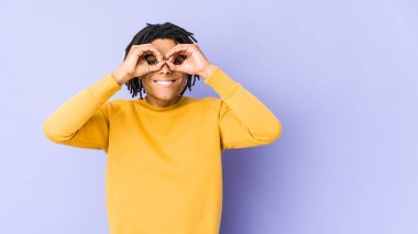 Rasta saç stili giyen genç siyahi adam gözlerinde işaret var.