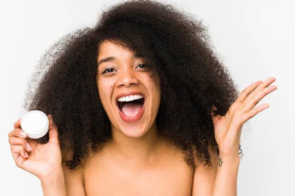 Joven Afro Mujer Sosteniendo Una Crema Hidratante Aislada Celebrando Una — Foto de Stock