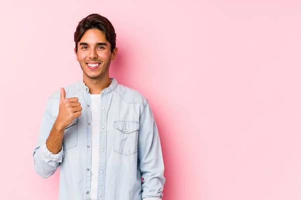 年轻的高加索男子 身披粉红的背景 面带微笑 竖起大拇指 — 图库照片