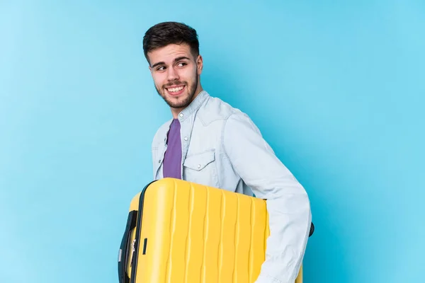 Young Caucasian Traveler Man Holding Suitcase Isolated Looks Aside Smiling — Stock Photo, Image